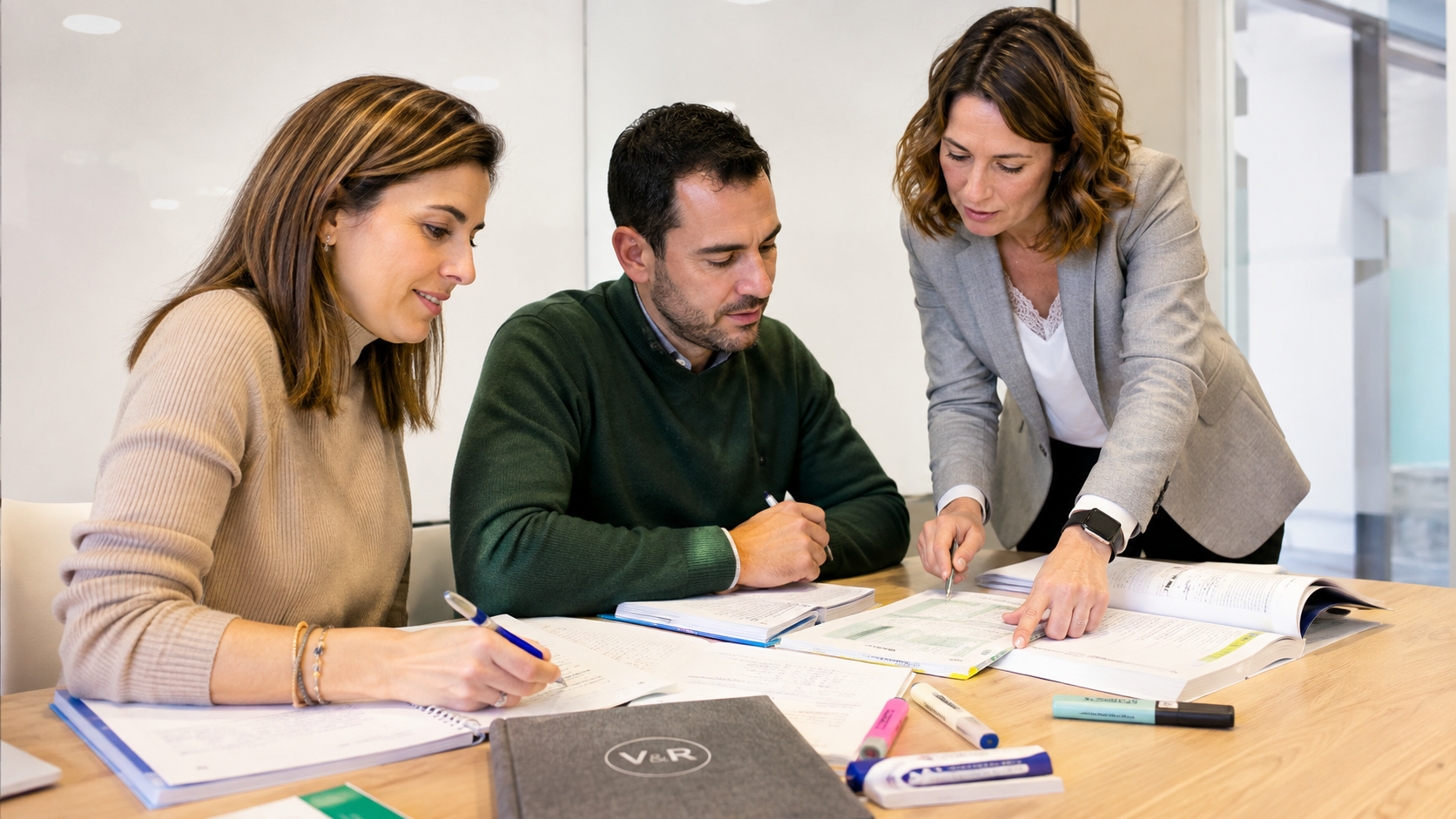 Docente orientando a dos alumnos adultos sobre su preparación universitaria